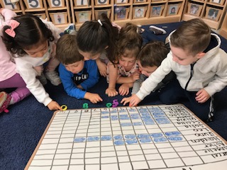 Preschool in Coral Gables where children sit viewing a chart