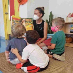 Preschool teacher at best preschool in Coral Gables reading to a group of children